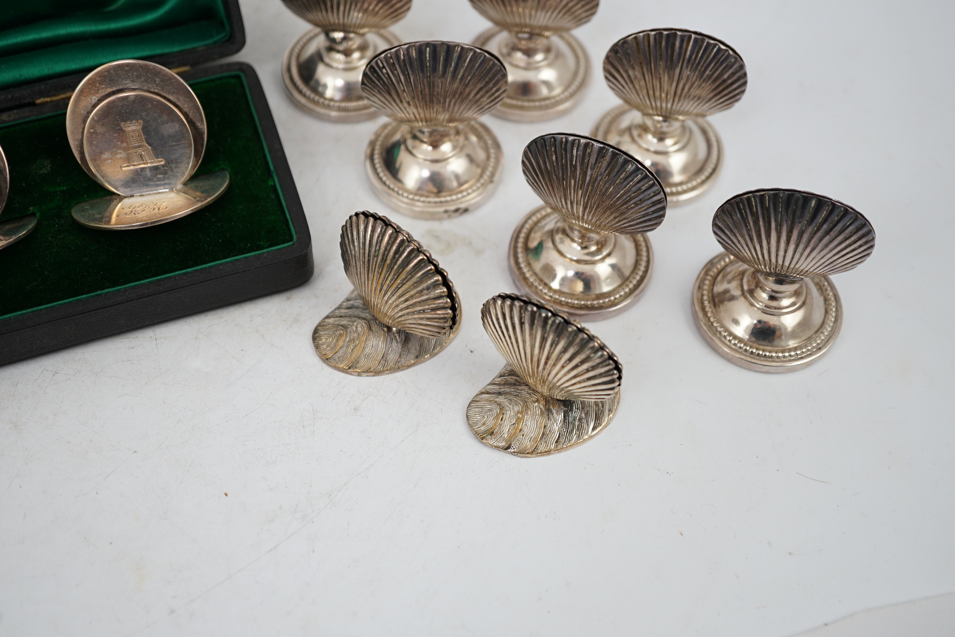 A cased set of four silver menu holders, engraved with castle crest, Sampson Mordan & Co, Chester, 1904, height 37mm, together with eight plated menu holders